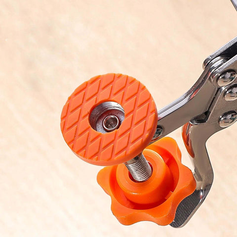 Woodworking hinge-boring guide wheel, orange 35mm, mounted on metal drilling clamp (close-up view)