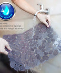 Person rinsing Pebble Sink Mat 2 Pack For Stainless Steel And Ceramic Sinks, PVC Dish Drying Mats with water, easy to clean feature displayed.
