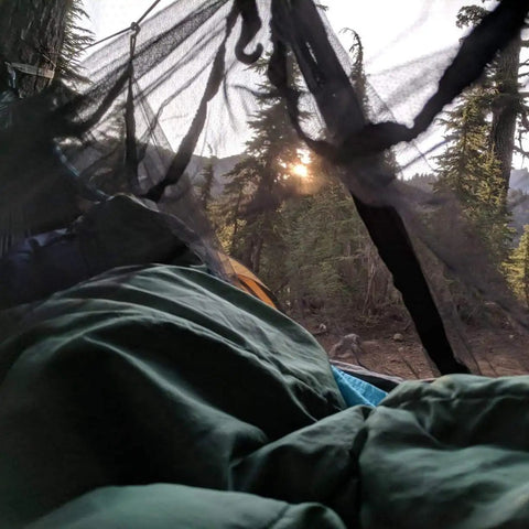 View from inside No-See-Um Hammock Mosquito Net XL 11FT By 4.6FT with 360 Degree Bug Protection, showing polyester mesh in a camping setup