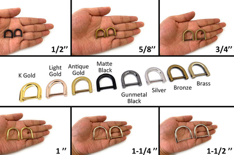 Assorted metal D rings in various sizes and finishes displayed on a hand for comparison.