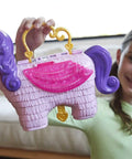 Girl holding Unicorn Party Playset With 25 Surprises, Pink Unicorn Toy With Purple Hair, Confetti Pinata Fun, Castle Adventure