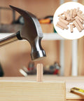 Hammer installing fluted dowel from Thirty Piece Wood Dowel Set With One Quarter Inch, Three Eighths Inch, And Five Sixteenths Inch Hardwood Fluted Dowels For Woodworking Crafts Furniture DIY Projects Grooved Pins And Pegs Pro Grade Tough And Ready For Any Build into wood surface, with dowels in inset.