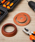 Two Set Leather Pitcher Pump Repair Kit with leather lower valves and cups next to installation tools on a wooden surface
