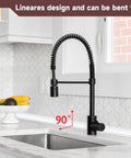 Modern kitchen faucet with black flexible hose, bent 90 degrees, above a stainless steel sink against a white tile backsplash.