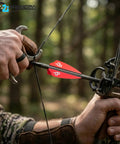 Archer holding a bow with arrows featuring white high performance arrow fletching vanes with Tri Fusion adhesion technology for target archery 2.5 inch length 36 pack top notch accuracy and inflight stability for competitive shooters.
