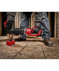 Worker using M18 FUEL 18V Brushless Cordless Gen 2 Super Hawg One Half Inch Right Angle Drill Tool Only for wood drilling on floor
