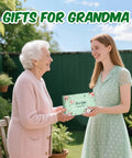 Young woman gifting All In One Garden Gift Set For Women Pink Edition With Hand Fork Trowel Gloves Apron And Tools Kit Gift Box Included Perfect Birthday Present For Mom Grandma Wife Garden Lovers to older woman.