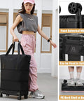 Front view of black fabric wheeled duffle bag with two carrying handles for travel.
