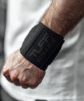 Person wearing 16 Inch Wrist Straps For Gym No Thumb Loops Durable Wrist Wraps For Powerlifting Weightlifting And Bench Press Support Strength Training Accessory For Enhanced Wrist Stability, black color.