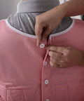 Person fastening buttons on Chenhon Criss Cross Chest Vest Restraint Secure Patient Safety For Bed Or Chair Use Adjustable Elastic Cotton Fabric.