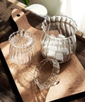 European Vertical Striped Glass Canister 420 Ml Dry Food Storage Jar Kitchen Counter with sugar cubes on a wooden tray.