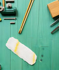 Top Tier 10 Piece Paint Roller Cover Refills For Smooth Wall And Ceiling Painting Ultra Thick Sleeves laid out on a turquoise wooden surface.