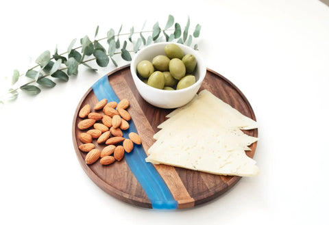 Solid Walnut Wood And Epoxy Resin Lazy Susan Turntable with cheese, almonds, and olives arranged elegantly.