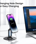 360 Degree Rotating Magnetic Phone Stand For Desk With Adjustable Foldable Aluminum MagSafe Holder And Non Slip Base, black, in use with charging iPhone 14 Pro.