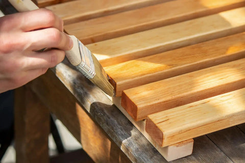 Applying Premium Clear Wood Stain With Semi Gloss Finish to wood slats for deck or fence weatherproofing.