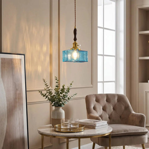 BBLLWJ 1-Pack Vintage Pendant Light for Kitchen Island, Brass & Wood Hanging Fixture with 78" Adjustable Cord, Blue Rectangular Hammered Glass Ceiling Light for Dining Room, Sink, Bedroom hanging over a table with decorative items.