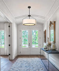 Grab This 20 Inch Drum Chandelier With 5 Lights For Instant Modern Farmhouse Vibes Featuring Soft White Linen Shades And Sleek Black Frames illuminating an entryway.