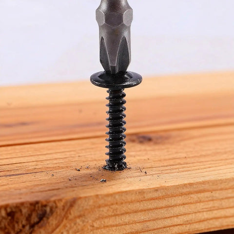 Close-up of a black carbon steel self-tapping screw with Phillips truss head driven into wood, 180 Piece Tough As Nails Bundle Of Black Carbon Steel Self Tapping Screws With Phillips Truss Heads That Blast Right Through Wood Furniture And Sheet Metal Every Single Time.