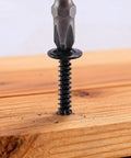Close-up of a black heavy duty truss head self tapping screw being drilled into wood, showing thread detail for strong holds.