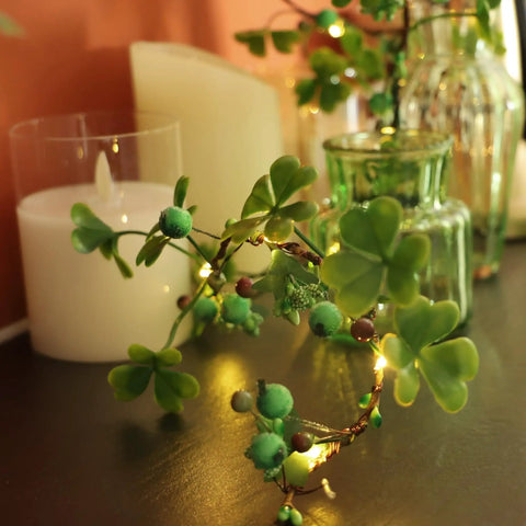 Multicolor Daisy Fairy Lights With Remote Battery Operated 40 LED Daisy String Lights For Bedroom And Outdoor Parties Easter Decor For Home And Seasonal Spring Vibes intertwined with greenery on a table setting.