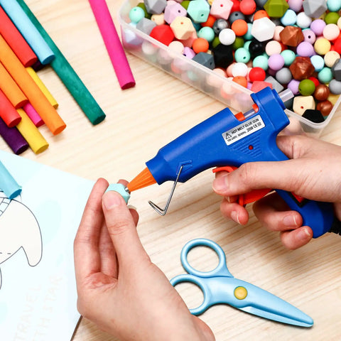 Using 4 Piece Mini Hot Glue Gun Set With 20 Glue Sticks For Kids Projects on crafts with colorful beads and paper.