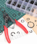All in One 4 in 1 Snap Ring Pliers Set With E Clip And C Clip Retaining Rings Kit 312 Piece Includes M1.5 To M10 E Clips And M4 To M28 C Clips Plus Tweezers For Auto DIY And Handyman Projects with red-handled pliers and assorted clips on a grid mat