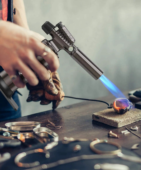 Person using Butane Torch Lighter With 25g Gas Capacity Refillable Blow Torch For Soldering Cooking And DIY Projects Large Continuous Adjustable Flame Up To 6 Inches Industrial Grade Gas Not Included on jewelry