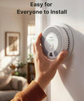 Person installing Six Pack Wireless Interconnected Smoke And Carbon Monoxide Detectors Featuring Ten Year Sealed Battery on wall.