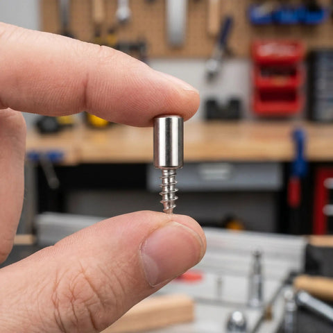 Close-up of a hand holding a screw from Heavy Duty Cabinet Shelf Support Pegs Kit With 150 Self Tapping Screws And 150 Sleeves Black