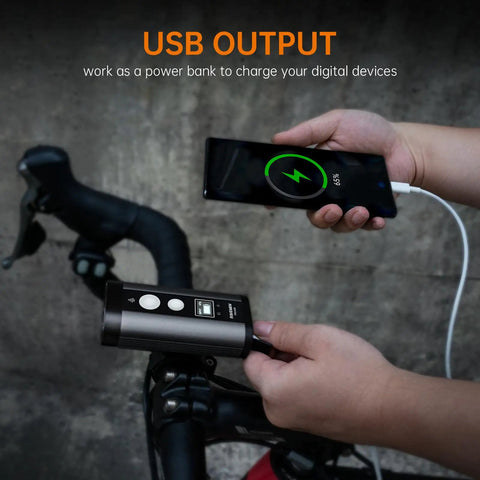 Person using PR2400 2400 Lumen Mountain Bike Light With OLED Runtime Display USB Output to charge a phone on bike handlebars
