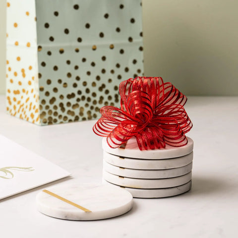 Dope White Marble Coasters Set Of 6 With Gold Brass Inlay For Luxury Aesthetic, tied with a red ribbon on a table