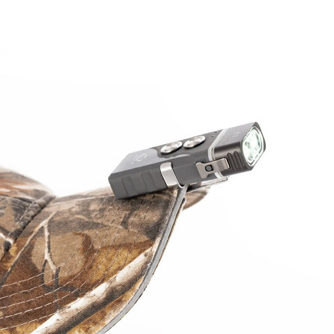EDC Keychain Flashlight Pocket Friendly With Hybrid Dual Power AAA Battery System clipped on camouflage cap