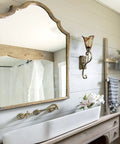 Rustic Wall Sconce Vanity Light With Amber Glow Glass Shade for bathroom, vintage metal in rubbed bronze finish next to mirror.