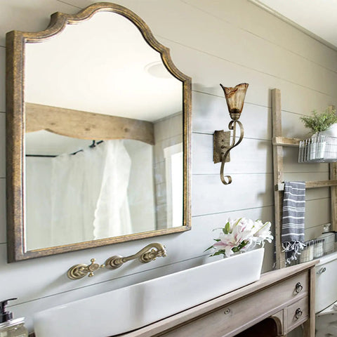 Rustic Wall Sconce Vanity Light With Amber Glow Glass Shade for bathroom, vintage metal in rubbed bronze finish next to mirror.