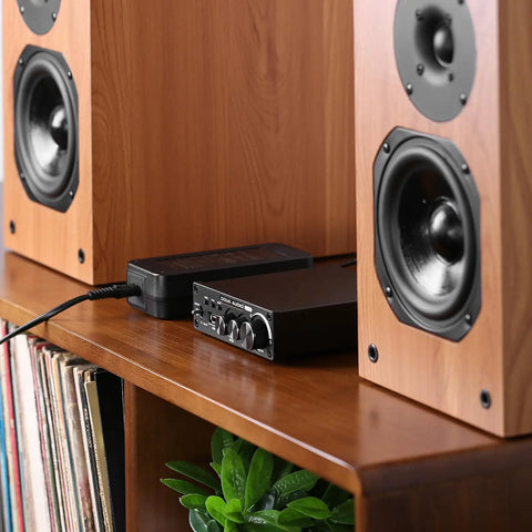 36V 6A Power Supply GaN Adapter with amplifier and speakers on a wooden shelf, showing compact and efficient setup.