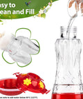 Person pouring liquid into Glass Hummingbird Feeder Outdoor Hanging With Built In Ant Moat And Four Bee Guard Perches Leak Proof 15 Ounce Capacity Stars Decor In Red Theme Ideal Gift For Women Men Moms Dads Who Love Backyard Bird Watching