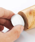 Hand holding Furniture Glide Nails And Holding Pins For Legs, Plastic And Iron Build, oval pin installing on wooden leg