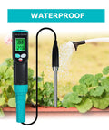 Pro Grade Soil EC Meter 2 In 1 Temperature Tester With Corded Sensor Backlit LCD Display beside watering can in garden