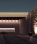 Outdoor landscape highlighted by low voltage plug in power supply kit with dual output, illuminating path and stone wall.