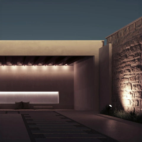 Outdoor landscape highlighted by low voltage plug in power supply kit with dual output, illuminating path and stone wall.
