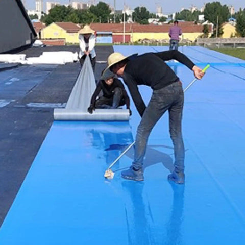 Workers applying Rock Solid Self Adhesive Waterproof Membrane Roll on a blue roof surface using a roller and smoothing technique.