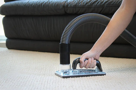 Sub Surface Extraction Tool 71 001 for carpet cleaning and odor elimination used on beige carpet near a black couch.