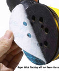 Hand holding a Sander Sandpaper 5 Inch 8 Hole Disc With Hook And Loop Pads 240 Grit for wood and metal, showing blue backing.