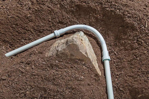One Inch PVC Lock Flexible Repair Coupling for Schedule 40 PVC Pipe installed in garden soil; O-ring ensures watertight seal.