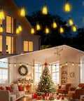 Outdoor Solar String Lights 50 Feet ST38 Shatterproof Bulbs Copper Wire Waterproof Patio Garden Lighting USB Charging Remote Control With 3 Modes Dimmable Solar Light No Outlet Needed For Camping Backyard And Patio Ambiance illuminating a festive outdoor and indoor setting with a Christmas tree and decorations.