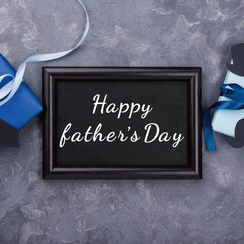Framed 'Happy Father's Day' sign placed between gift boxes with ribbons, showcasing vinyl lettering design potential.