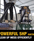 Person using StealthSonic 10 Gallon Wet Dry Shop Vacuum With Ultra Quiet Motor For Car Garage Workshop Jobsite Attachments Includes Hose Pro Grade Nozzle Crevice Tool Floor Nozzle And More 5 Peak HP Heavy Duty Suction to clean wet floor in garage.
