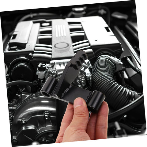 FELTECHELECTR flywheel holding tool held in hand in a car engine bay; black metal bracket