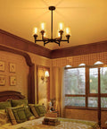 Black Farmhouse Chandelier With Six Clear Glass Shades Hanging Over Dining Table Featuring Sturdy Metal Frame And Sleek Modern Design That Hits Different For A Killer Centerpiece Vibe In Any Home Space, in cozy bedroom setting.