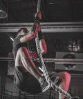 Man climbing on gym rope for strength training, using Outdoor Climbing Rope For Fitness And Strength Training, 1.5 Inch Gym Rope.